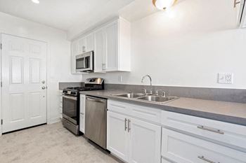 A kitchen with white cabinets and stainless steel appliances.